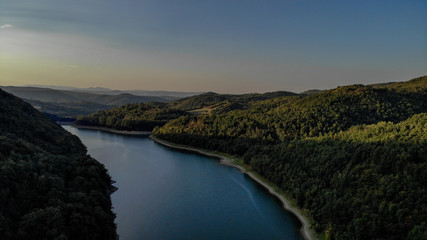 Aerial view, sunset in first day of autumn, green and yellow leaves on trees - lake Vodojaza near the Kragujevac