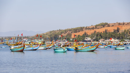 Fototapeta na wymiar Fishing harbor full of boats in a bay in Mui Ne, Vietnam