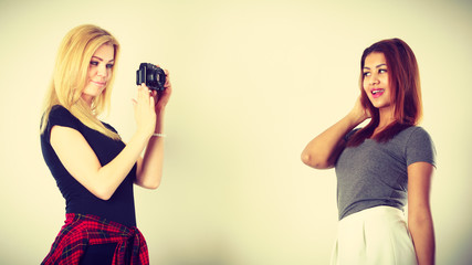 Blonde girl photographing woman