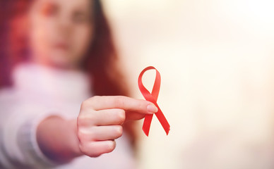 The red ribbon of the girl. The girl is holding a red ribbon. He