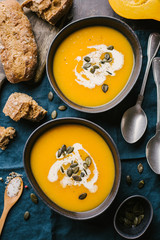 Autumn pumpkin creamy soup in bowls