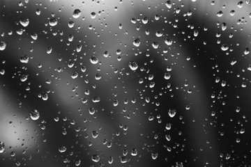 Obraz premium Rain drops on window glass. Natural gray water background