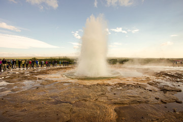 Iceland Strokkur geysir with tourists watching the eruption