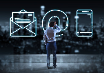 Businessman watching contact icon on the top of a building
