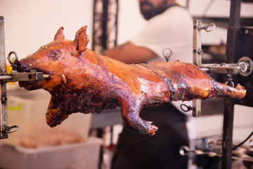 Grilled pig on spit street food festival - obrazy, fototapety, plakaty