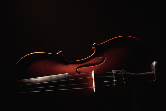 part of a violin on a black background with hard light