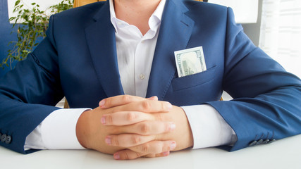 Closeup photo of big stack of money showing businessman's pocket