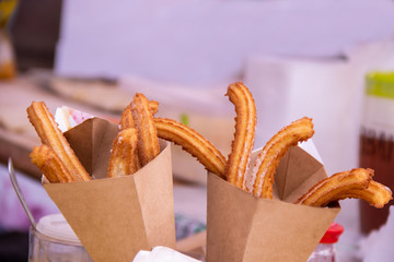 Delicious churros sticks deep fried in paper bag with powdered sugar