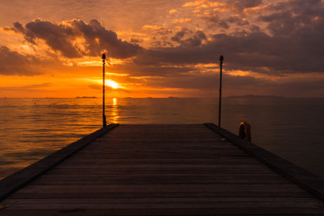 Obraz premium Wood bridge to the sea with sunset.
