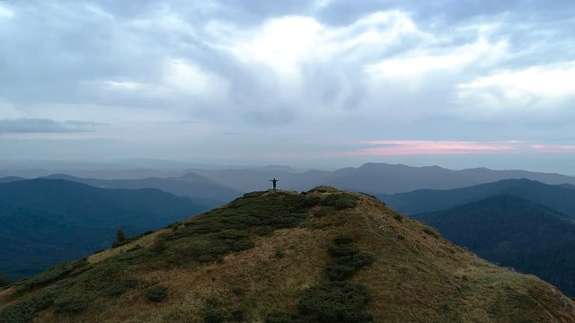 The happy man on the top of the mountain enjoying the scenic landscape