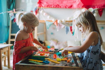 two little girls playimg with play dough at home