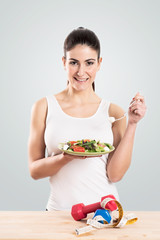 Healthy young woman eating a salad