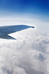 Airplane Wing Out of Window with Clouds and Sky