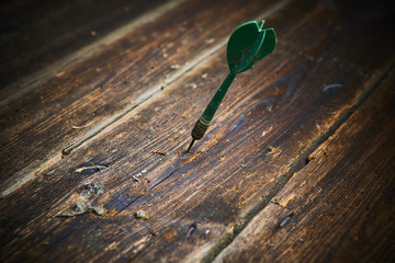 Dart stuck in old wooden board