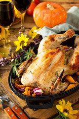 Thanksgiving Day food concept. Homemade Roasted Turkey with Pumpkin and red wine in glasses on rustic background.