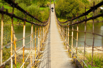 The old suspension bridge over the river in the mountains