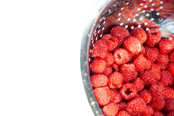 Delicious fresh and wet red raspberry in a colander for washing isolated at white background