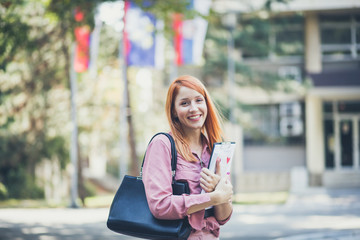 I love University life. Red haired woman looking at camera.