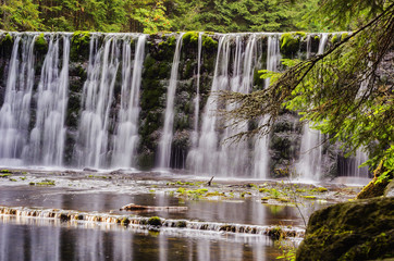 large waterfall on a mountain river in the forest
