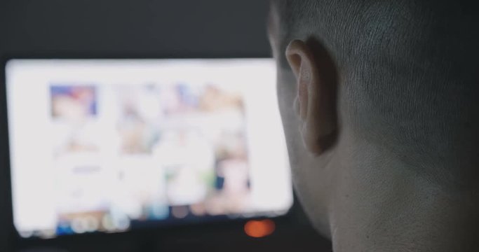 Back view of Young Man secretly watching porn sites at night. Closeup