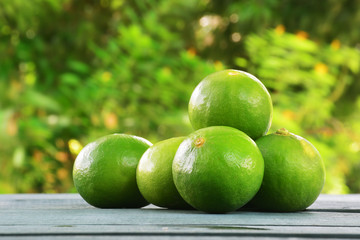 Fresh green limes on wooden table.