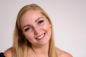 Naklejka premium Studio portrait of a beautiful blonde girl close-up on a white background in different poses with different emotions