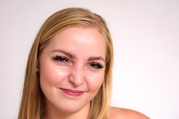 Fototapeta premium Studio portrait of a beautiful blonde girl close-up on a white background in different poses with different emotions