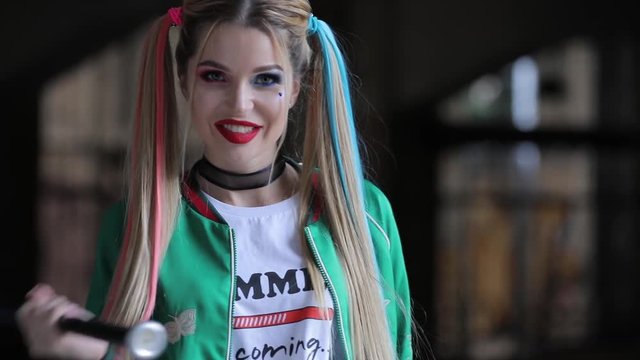 Unusual woman with fantastic makeup and unconventional hairstyle holding baseball-bat