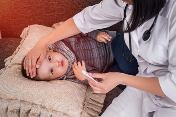 Doctor with little patient which have a fever