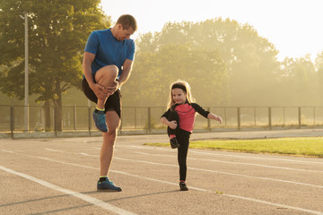 Dad and daughter go in for sports.Dad and daughter at the stadium.