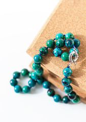 Beads from turquoise lie on a box of cork tree