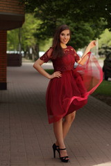 Happy beautiful woman in red summer dress walking and running joyful and cheerful smiling in the...