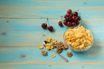 Tasty cornflakes with walnut and strawberries in glass bowl