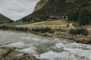 A fast river flows through a steep hilly mountain gorge.