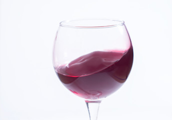 A glass with red wine on a white background. Isolate