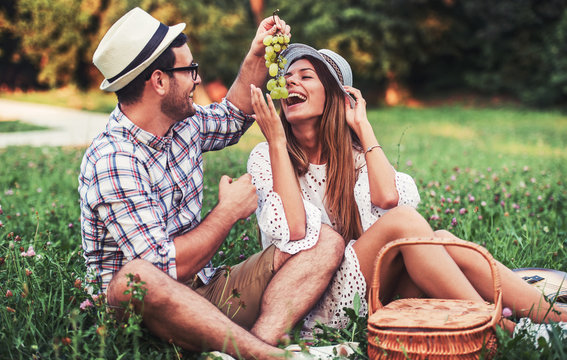 Loving couple enjoying picnic in the park. Love and tenderness, dating, romance, lifestyle concept