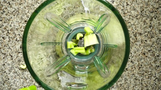 	Stalk of an apium fall in a blender bowl. Slow motion.	Shooting in kitchen. Top view.	