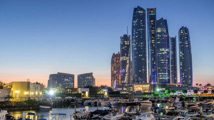 Al Bateen marina Abu Dhabi dag naar nacht timelapse met moderne wolkenkrabbers op achtergrond