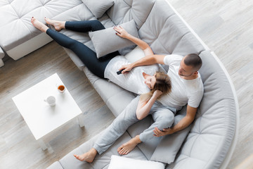 Young couple resting on sofa at home. Family relaxation lifestyle