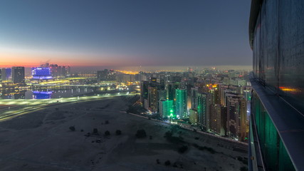 Abu Dhabi city skyline with skyscrapers before sunrise from above night to day timelapse