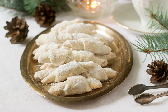 Traditional Romanian or Moldovan shortcake cookies with jam stuffing and a cup of tea on the background of winter decor.
