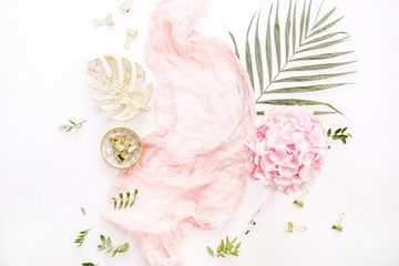 Stylish composition with pink hydrangea flowers bouquet, tropical palm leaf, pastel blanket,...