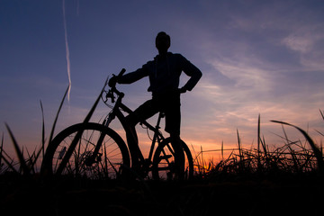 Fototapeta na wymiar Silhouette of man cyclist on bike, bicycle against the sunset sky