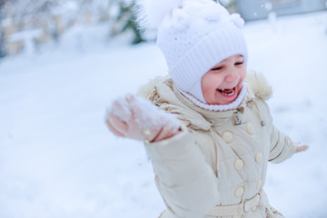 Obraz premium girls play snowballs in yard of kindergarten.