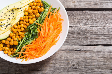 Buddha bowl with avocado , cucumber , carrot and chickpea