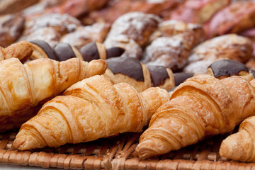 beautiful appetizing croissants on a wicker napkin in a cafe or on a storefront in a store