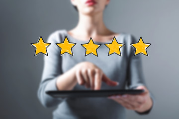 Five star rating with business woman using a tablet computer