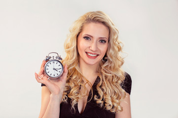 happy woman smiling and holding alarm clock
