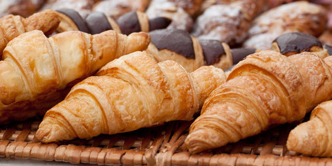 beautiful appetizing croissants on a wicker napkin in a cafe or on a storefront in a store