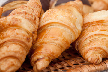 beautiful appetizing croissants on a wicker napkin in a cafe or on a storefront in a store